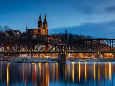 a bridge over a river with a castle in the background at Design Spacy Apartman by City Center in Prague