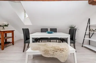a dining room with a white table and black chairs at Picturesque Apt in Lesser Town with lovely Terrace in Prague