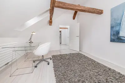 a glass desk and a white chair in a room at Picturesque Apt in Lesser Town with lovely Terrace in Prague