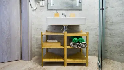 a bathroom with a sink and a shelf with towels at Flying Bed Apartment close to Prague Castle and Airport in Prague