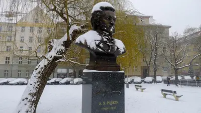 a statue in the snow next to a tree at Flying Bed Apartment close to Prague Castle and Airport in Prague