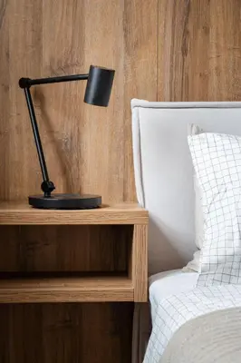 a black lamp on a table next to a bed at Modern Studio in Karlin - Fully Equipped in Prague