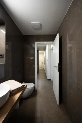 a bathroom with two sinks and a toilet and a hallway at Modern Studio in Karlin - Fully Equipped in Prague
