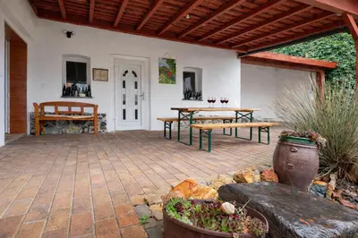 a patio with two picnic tables and a wooden roof at Kovárna Klapý pod Hazmburkem - České středohoří in Klapý