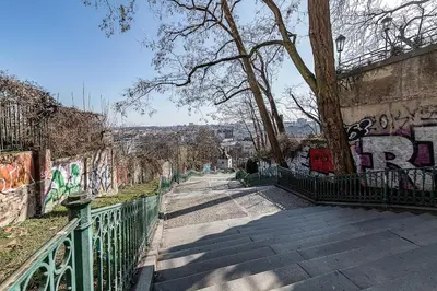 a walkway with graffiti on the side of a wall at Rooftop APT with beautiful view and free parking in Prague