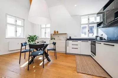 a kitchen with white cabinets and a table and chairs at Rooftop APT with beautiful view and free parking in Prague