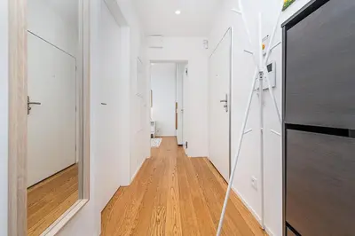 a hallway with white walls and a wooden floor at Rooftop APT with beautiful view and free parking in Prague