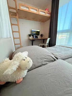 a bedroom with a bed with a stuffed sheep on it at Easy City Access Bright 1BR with Underground Parking in Prague