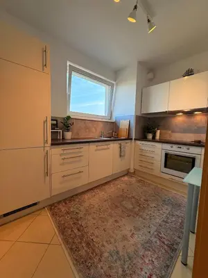 a kitchen with white cabinets and a rug at Easy City Access Bright 1BR with Underground Parking in Prague