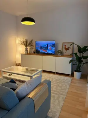 a living room with a blue couch and a tv at Easy City Access Bright 1BR with Underground Parking in Prague