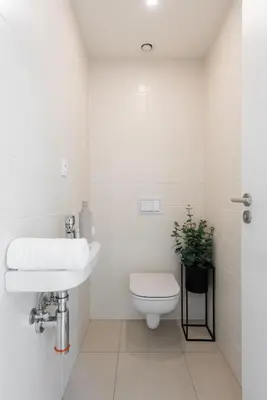 a white bathroom with a toilet and a sink at Stylish 2BDR Apartment with Free Parking & Terrace by EasyBNB Premium in Prague