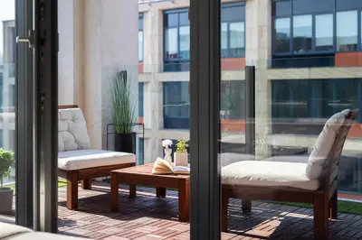 a patio with two chairs and a coffee table on a balcony at Stylish 2BDR Apartment with Free Parking & Terrace by EasyBNB Premium in Prague