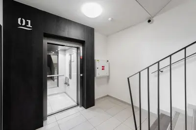 a hallway with a glass door and a staircase at Stylish 2BDR Apartment with Free Parking & Terrace by EasyBNB Premium in Prague