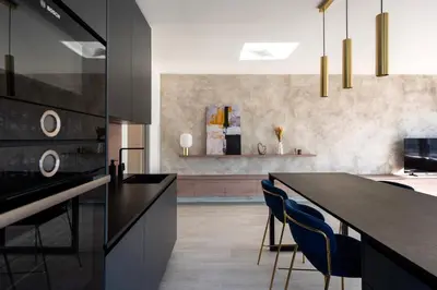 a kitchen with a black counter and blue chairs at Stylish 2BDR Apartment with Free Parking & Terrace by EasyBNB Premium in Prague