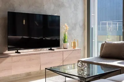 a living room with a flat screen tv on a entertainment center at Stylish 2BDR Apartment with Free Parking & Terrace by EasyBNB Premium in Prague