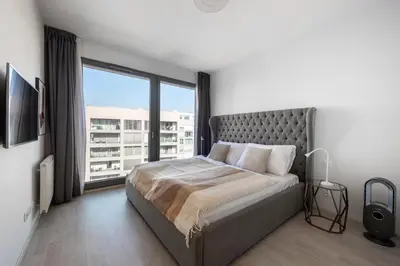 a bedroom with a bed and a large window at Stylish 2BDR Apartment with Free Parking & Terrace by EasyBNB Premium in Prague