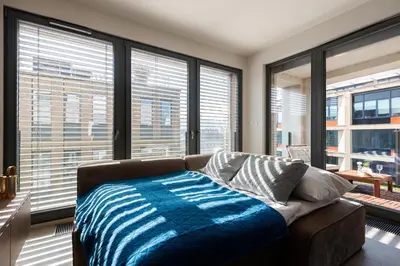 a living room with a couch with a blanket on it at Stylish 2BDR Apartment with Free Parking & Terrace by EasyBNB Premium in Prague