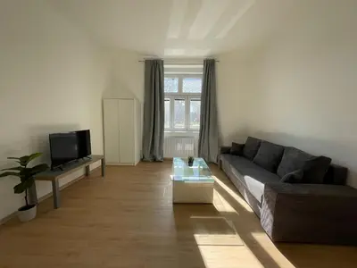a living room with a couch and a tv at Cozy & Spacious Apartment for 5 Guests in Prague in Prague