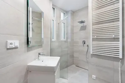 a white bathroom with a sink and a shower at Cozy & Spacious Apartment for 5 Guests in Prague in Prague