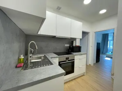 a kitchen with white cabinets and a sink at Cozy & Spacious Apartment for 5 Guests in Prague in Prague