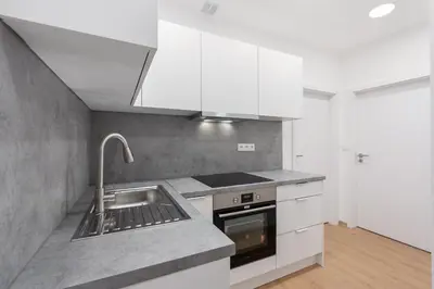 a kitchen with white cabinets and a sink at Cozy & Spacious Apartment for 5 Guests in Prague in Prague