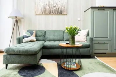 a living room with a green couch and a table at Nusle Brewery Design Apartment in Prague