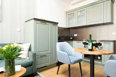a kitchen with a table with two chairs and wine glasses at Nusle Brewery Design Apartment in Prague