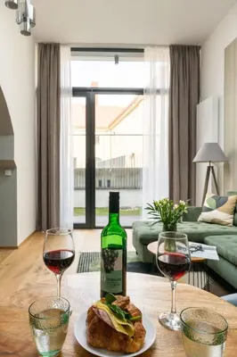 a table with a bottle of wine and two glasses at Nusle Brewery Design Apartment in Prague