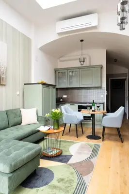 a living room with a green couch and a table at Nusle Brewery Design Apartment in Prague