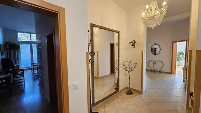 a hallway with a mirror and a dining room at Grand Prague Residence in Prague