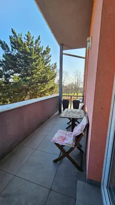 a patio with a table and a chair on a balcony at Grand Prague Residence in Prague
