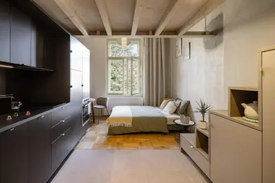 a small bedroom with a bed and a kitchen at Cozy apartment in Vinohrady café & culture zone in Prague