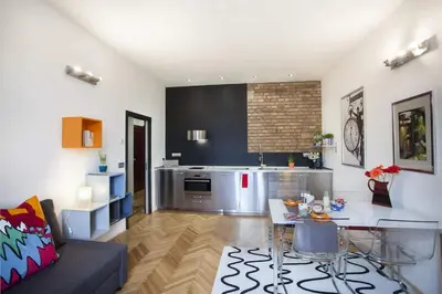 a living room with a table and a kitchen at Central river view in Prague