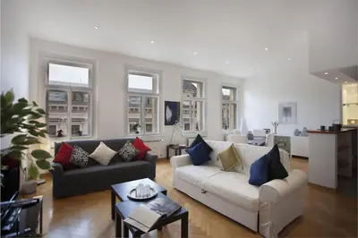 a living room with two couches and a table at Charles Bridge Apartment in Prague