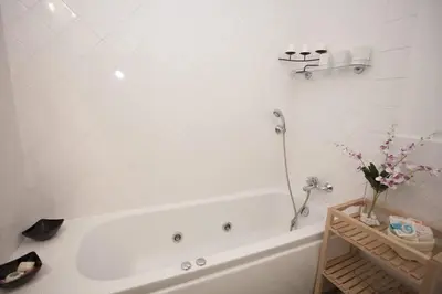 a bathroom with a white tub and a sink at Charles Bridge Apartment in Prague