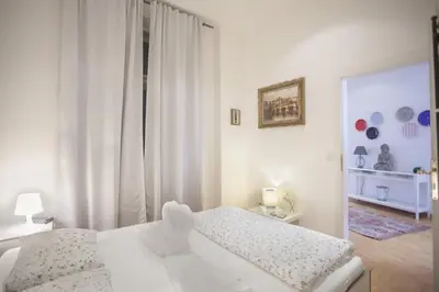 a white bedroom with a bed and a window at Charles Bridge Apartment in Prague