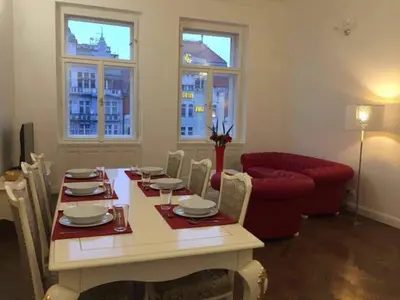 a dining room with a table and a red couch at Luxury flat in Wenceslas Square in Prague