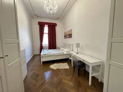 a bedroom with a bed and a desk and a window at Luxury flat in Wenceslas Square in Prague