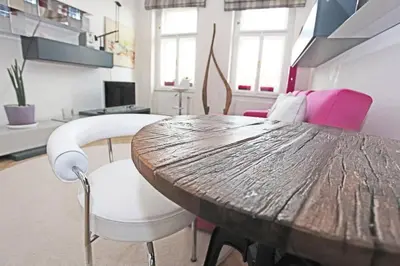 a dining room with a wooden table and chairs at Stylish river-view apartment in Prague