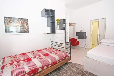 a bedroom with a bed and a red chair at Stylish river-view apartment in Prague