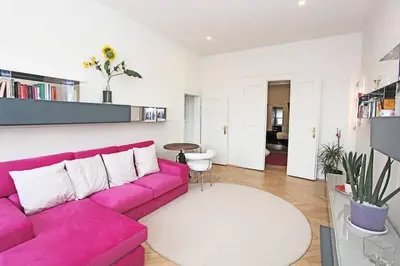 a living room with a pink couch and a table at Stylish river-view apartment in Prague