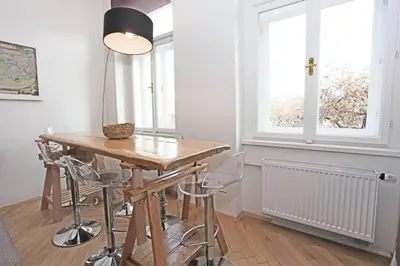 a room with a table with stools and a lamp at Stylish river-view apartment in Prague