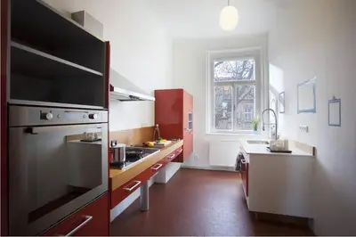 a kitchen with red and white cabinets and a sink at Spectacular Riverview apartment in Prague