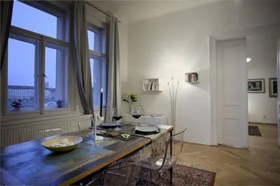 a living room with a table and a large window at Spectacular Riverview apartment in Prague