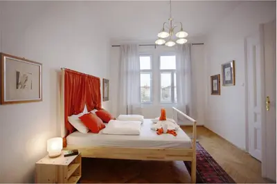 a bedroom with a bed with red pillows and a window at Spectacular Riverview apartment in Prague