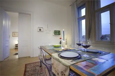 a dining room table with glasses of wine on it at Spectacular Riverview apartment in Prague