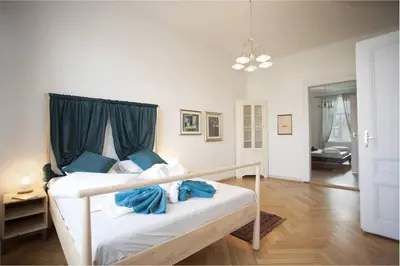 a white bed with blue pillows in a room at Spectacular Riverview apartment in Prague