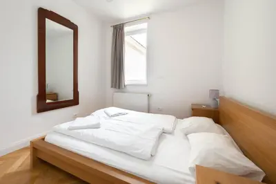 a white bed in a room with a mirror at Charles bridge unique maisonette in Prague