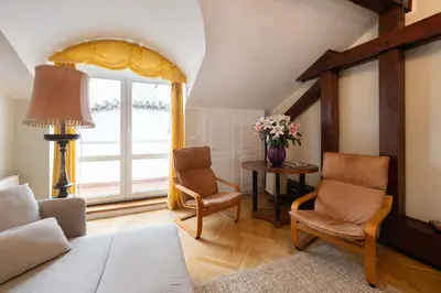 a living room with two chairs and a window at Charles bridge unique maisonette in Prague