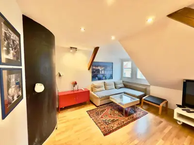 a living room with a couch and a tv at Attic 15 min to Charles Bridge in Prague